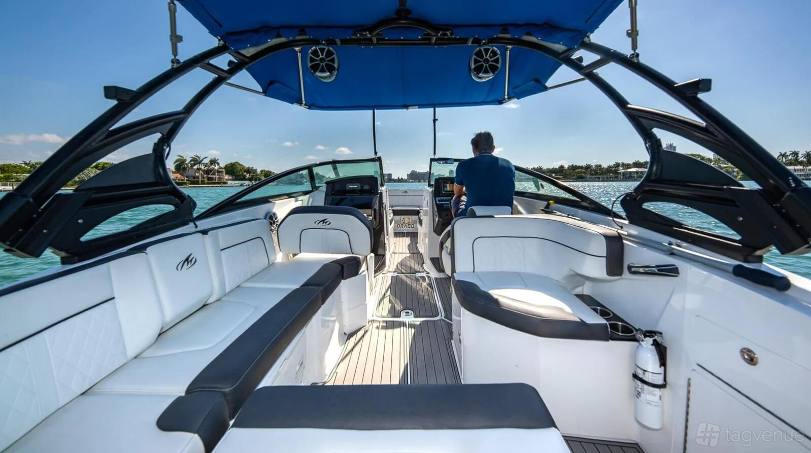 A boat with white leather seating, open deck layout, and shaded canopy on the water at Miami Beach Yachts.