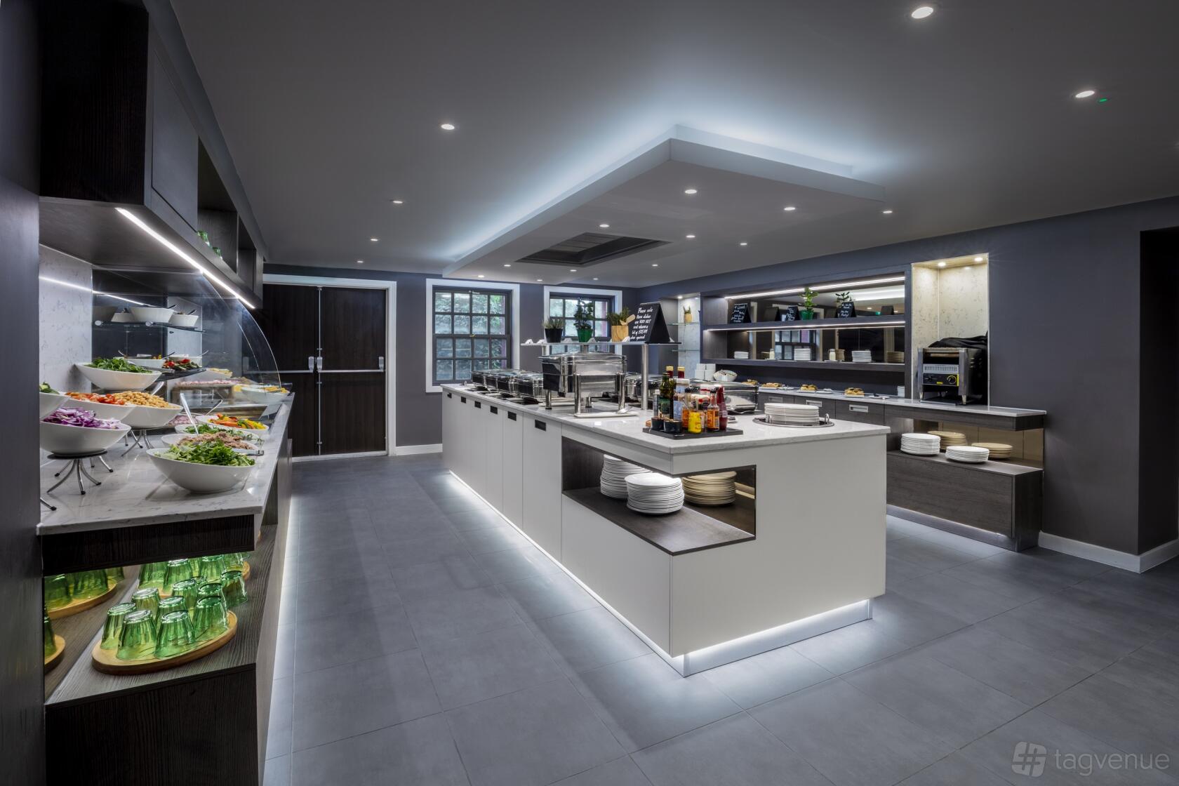 A hotel restaurant with a central buffet island, salad bar, and open shelving at Radisson Blu Hotel, Edinburgh City.