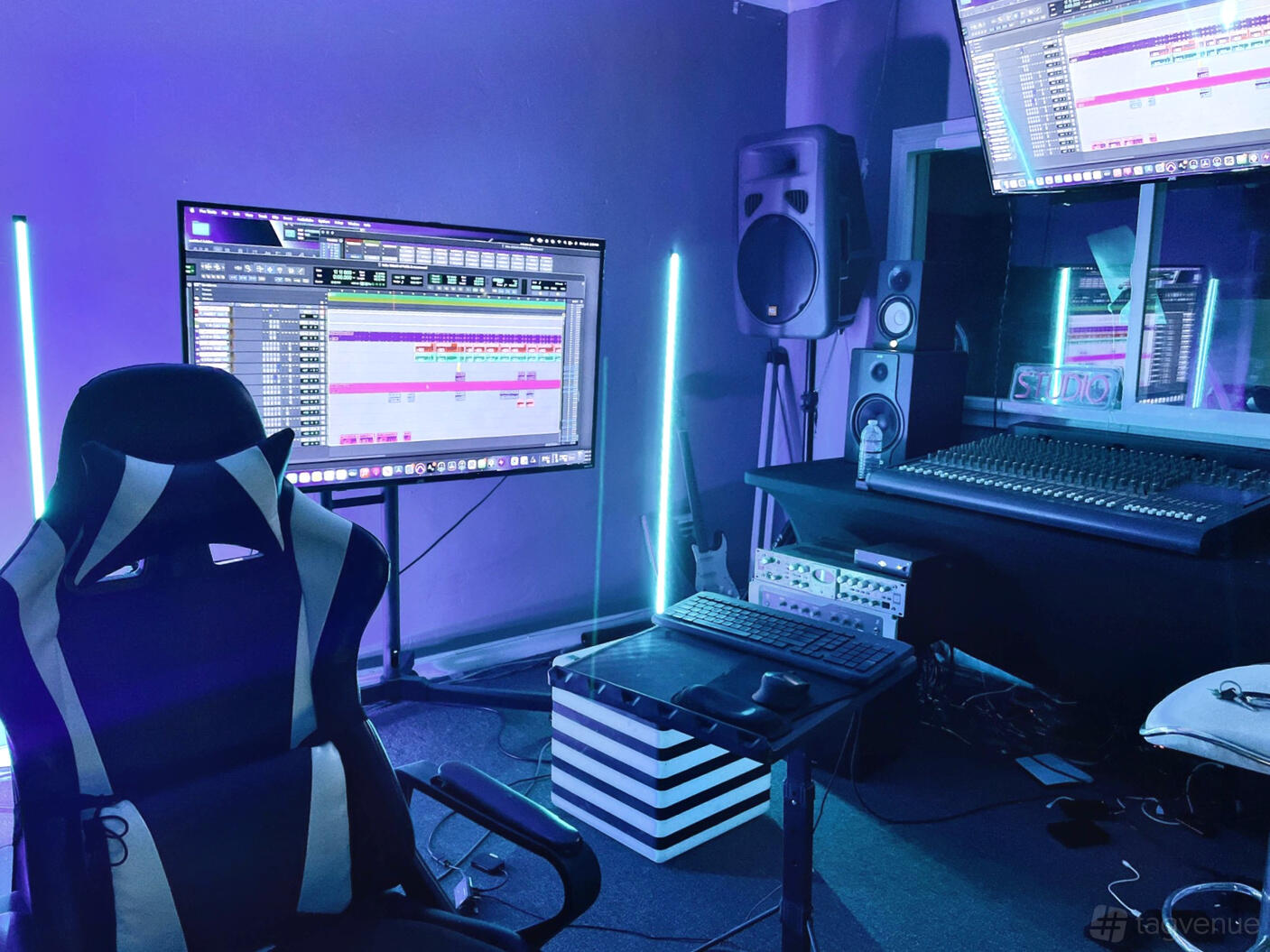 A recording studio with LED lighting, large mixing desk, digital audio workstation screens, and studio monitors at @BrickhouseVegas Recording Studio.