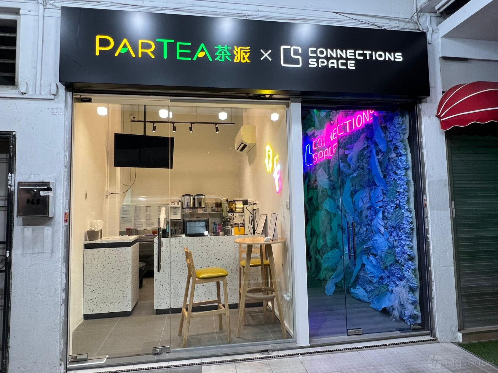 A versatile event space with floor-to-ceiling windows, bar counter, and neon-lit wall at Connections Space X Partea.