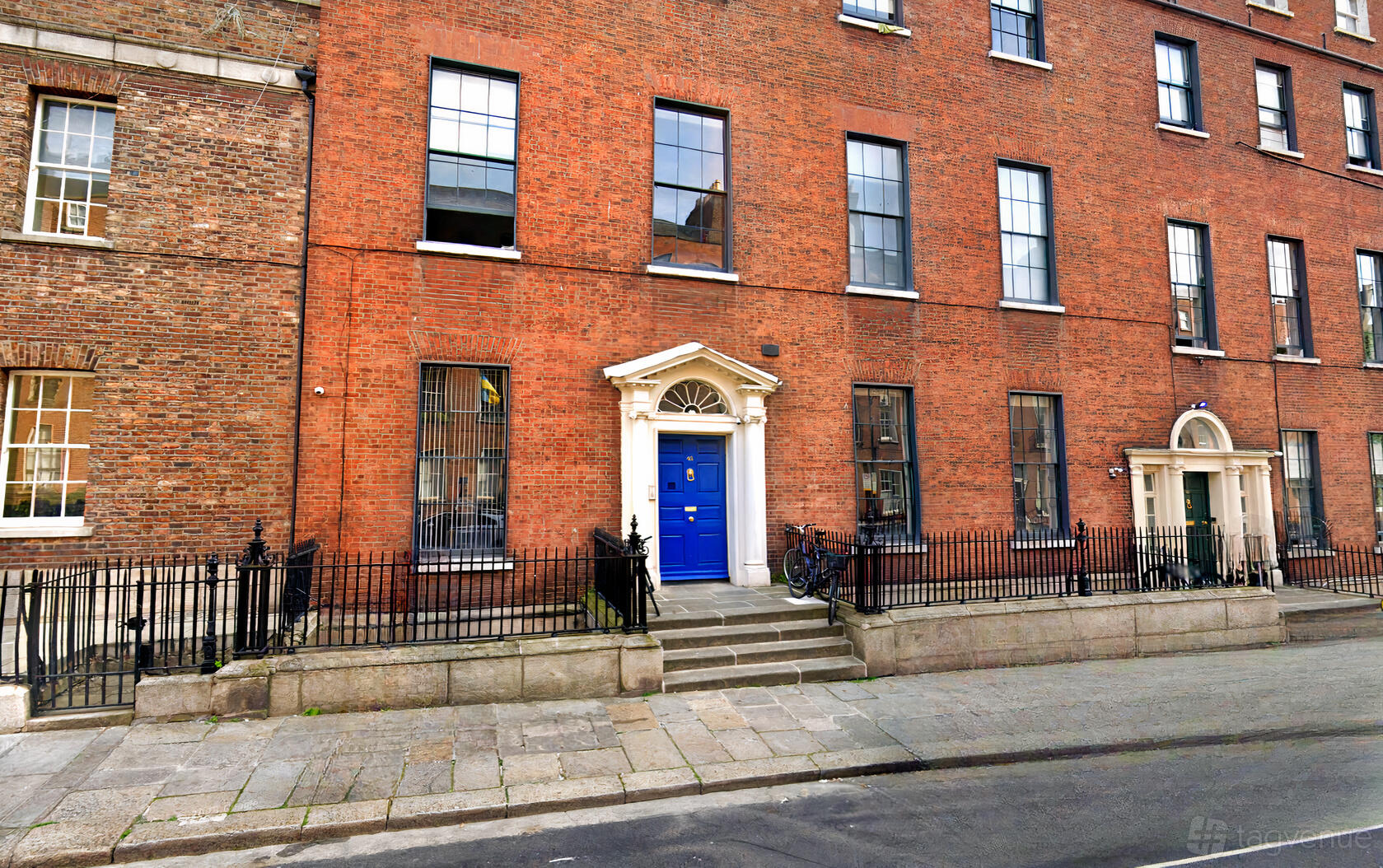 A meeting centre with a classic red brick facade, blue door, and decorative white doorframe at North Great George's Street.