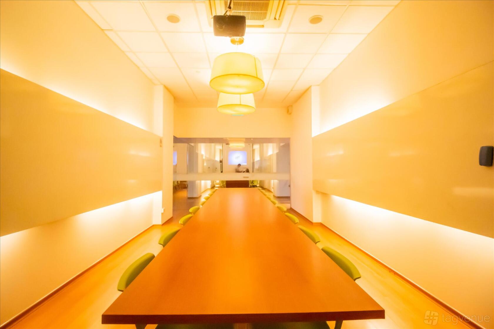 A university meeting room with a long wooden conference table, green chairs, and pendant lighting at ERC Institute.