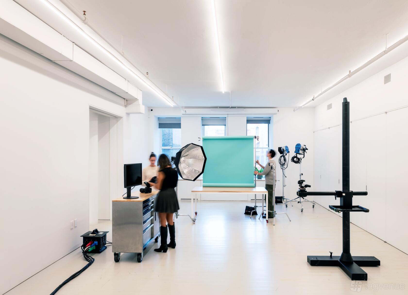 A photo studio with white walls, a seamless backdrop, studio lights, and photography equipment at studioCASE.