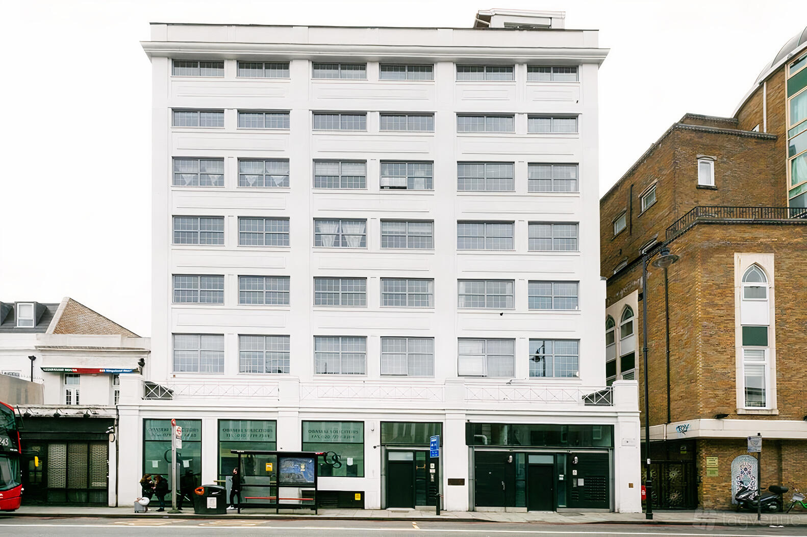 A multi-story white building with tall windows and ground-floor entrances at House of Transformation - Film Studio.