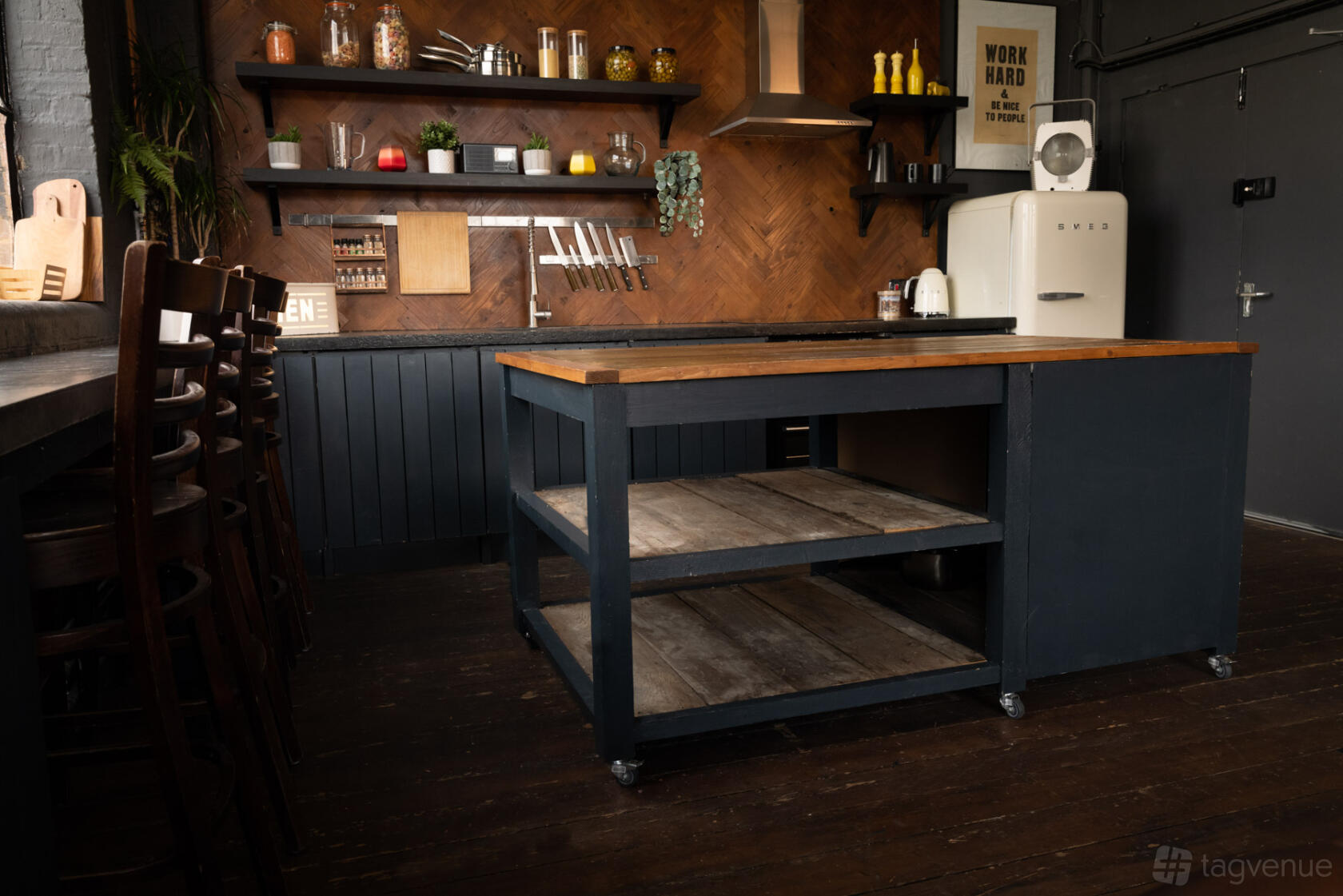 A kitchen with open wooden shelves, a central island, and vintage fridge at Crixus Studios.