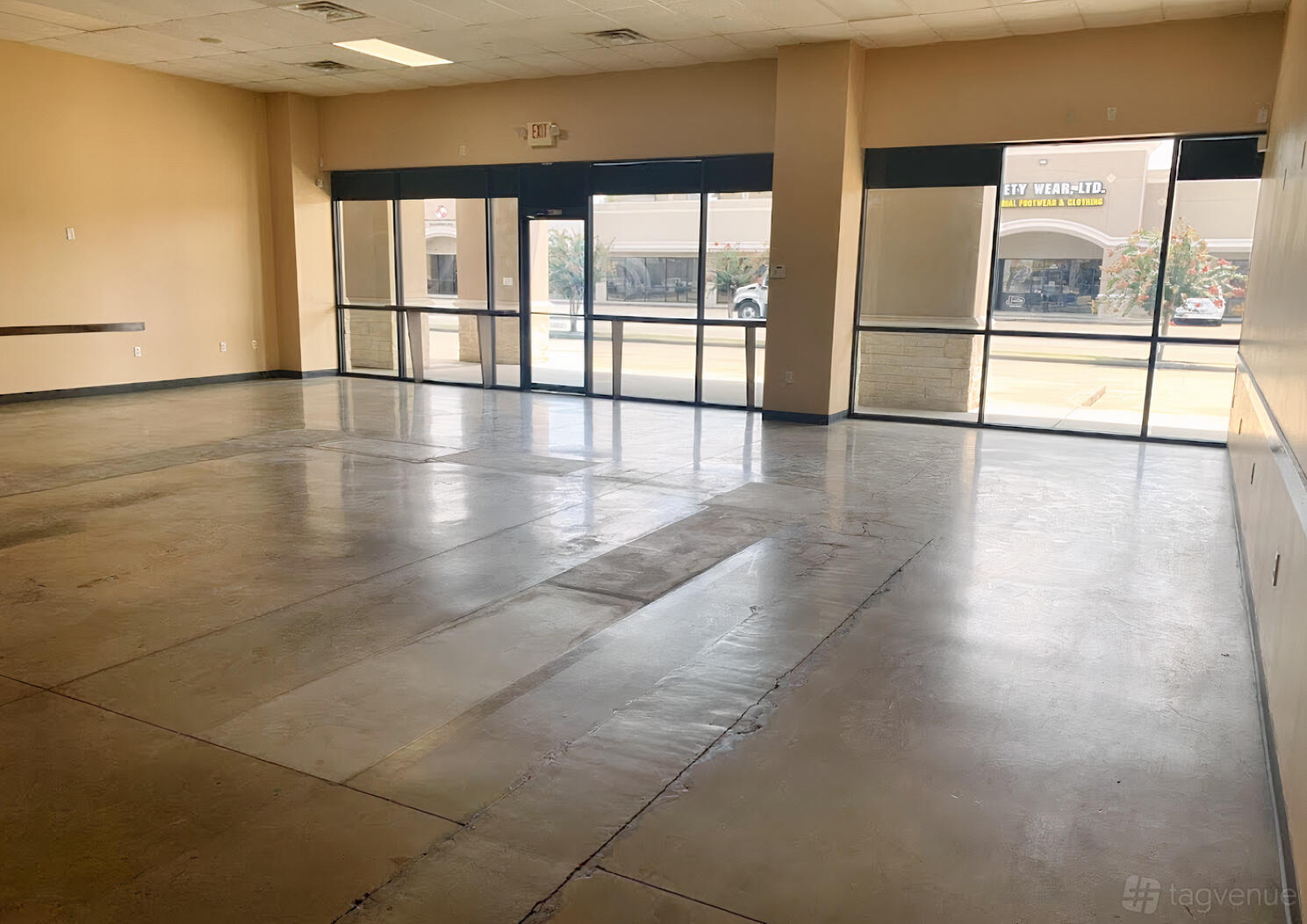 An event venue with large floor-to-ceiling windows and polished concrete floors at City Place Events Houston.