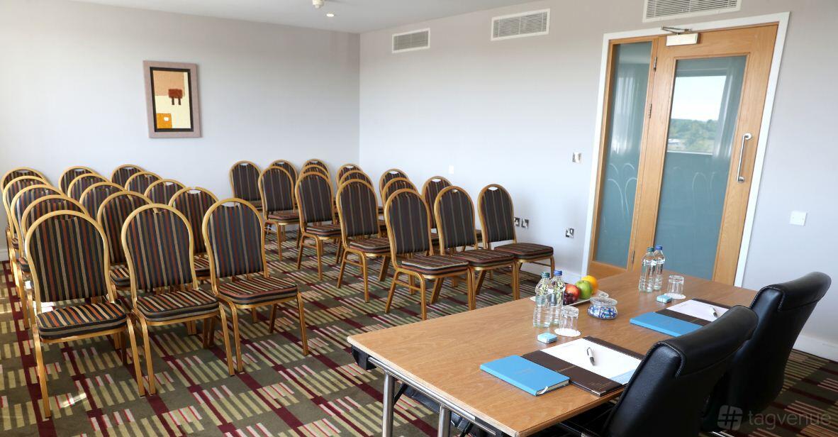 A hotel training room with striped chairs in rows, patterned carpet, and a setup table at CityNorth Hotel & Conference Centre.