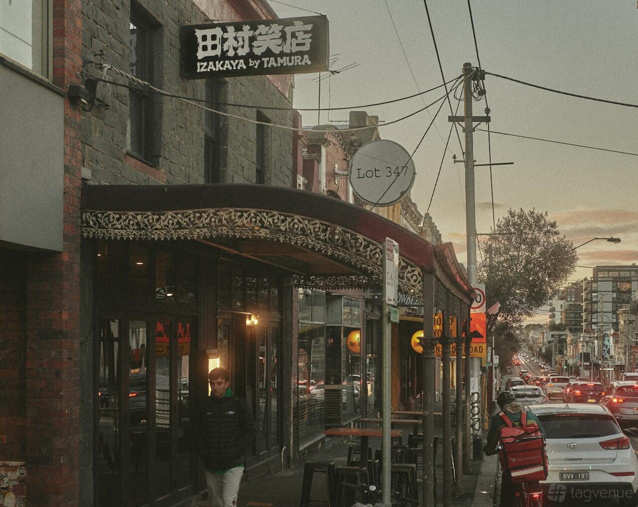 A restaurant exterior with a decorative awning, large windows, and street views at Izakaya by Tamura.