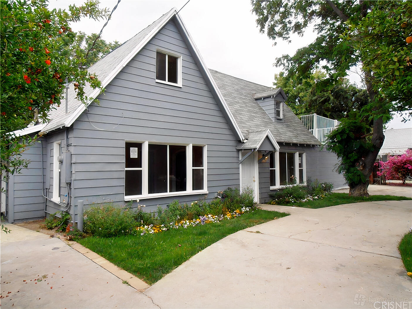 A grey house-style apartment with multiple windows, pitched roof, and a garden at FWD Vision Spaces Elevate.