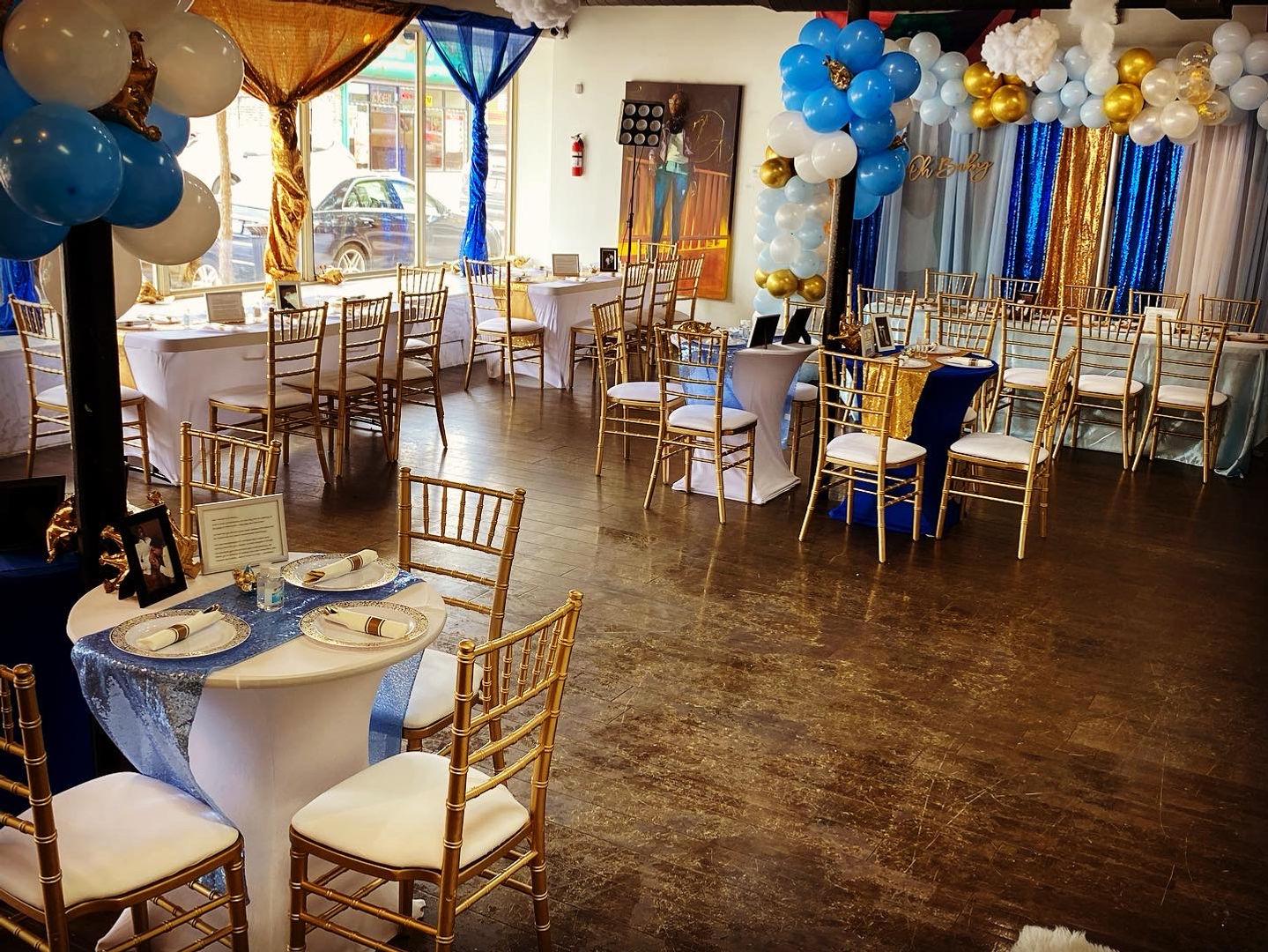 A function room with gold chairs, round and rectangular tables, and balloon decorations at Luxe B Studio.