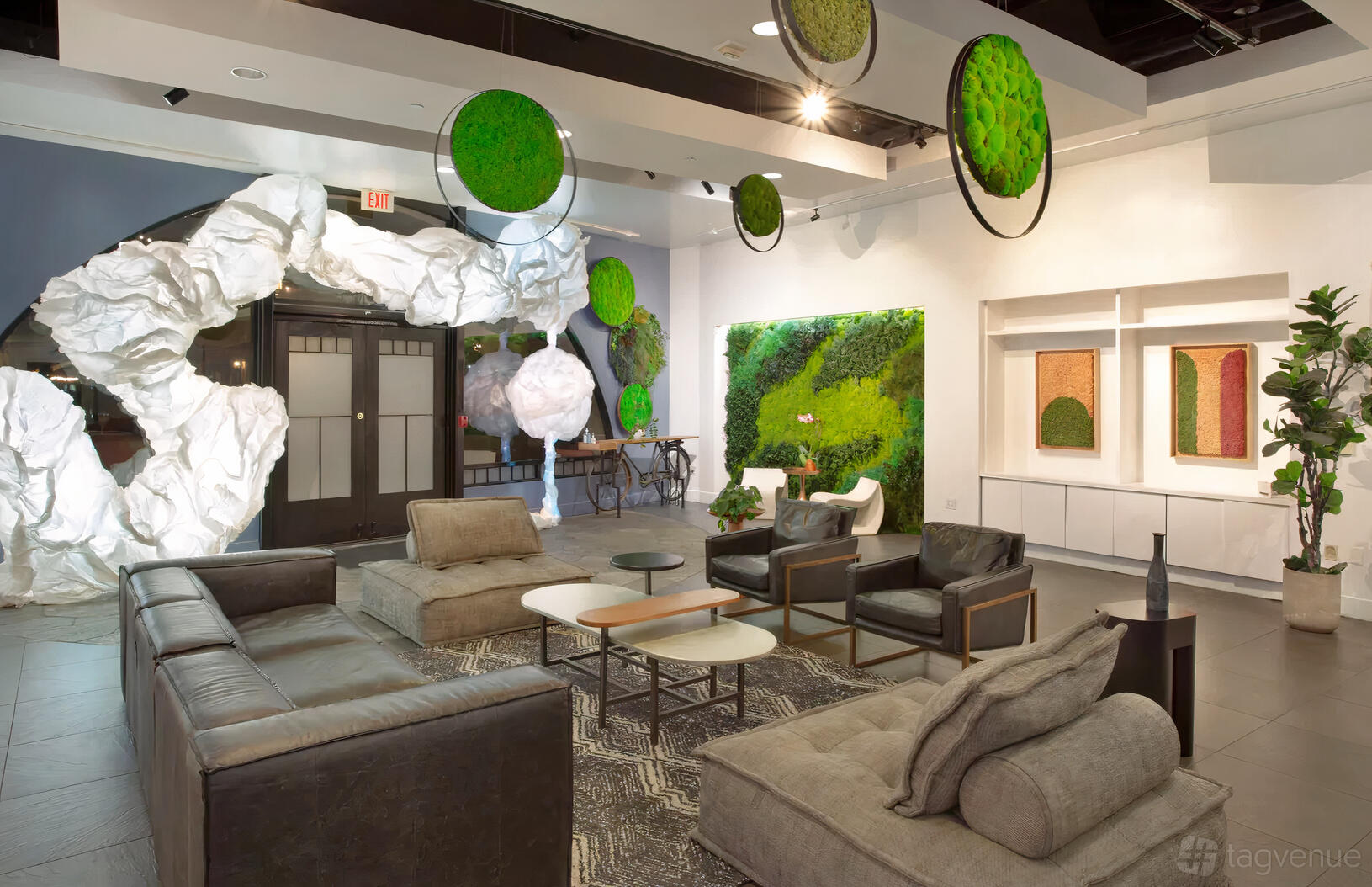 An event venue with lounge seating, modern green wall art, and sculptural white decor at Studio Mahal.