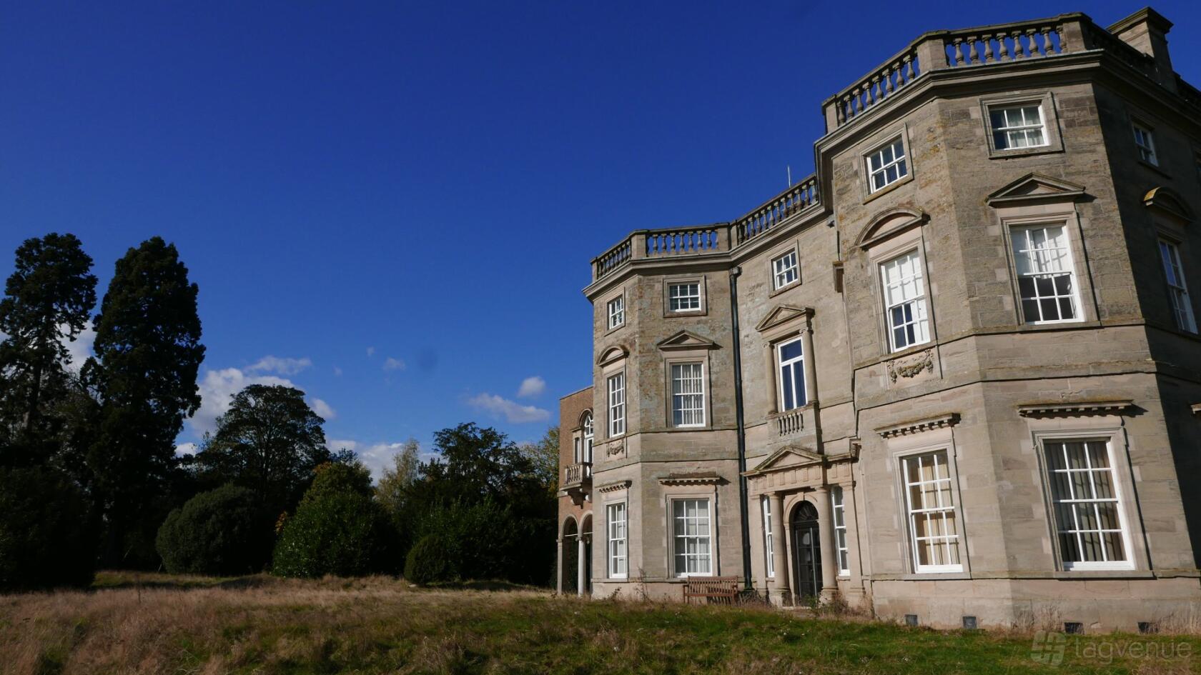 A historic hall with stone facade, tall sash windows, and classical architectural details at Bourton Hall.