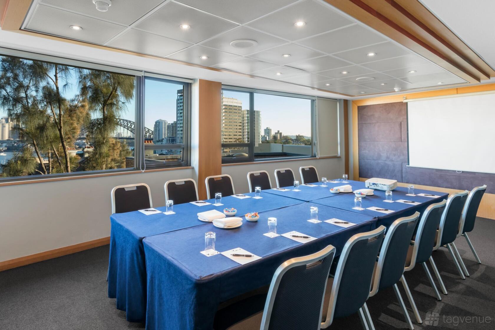 A meeting room with large windows, natural light, and a U-shaped table setup at View Sydney.