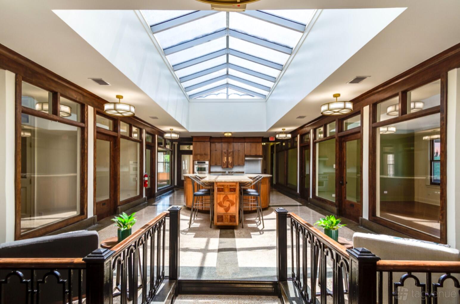 An event space in a coworking venue with a glass ceiling, wood accents, and central island at The Boulevard Arcade by CrossFunction.
