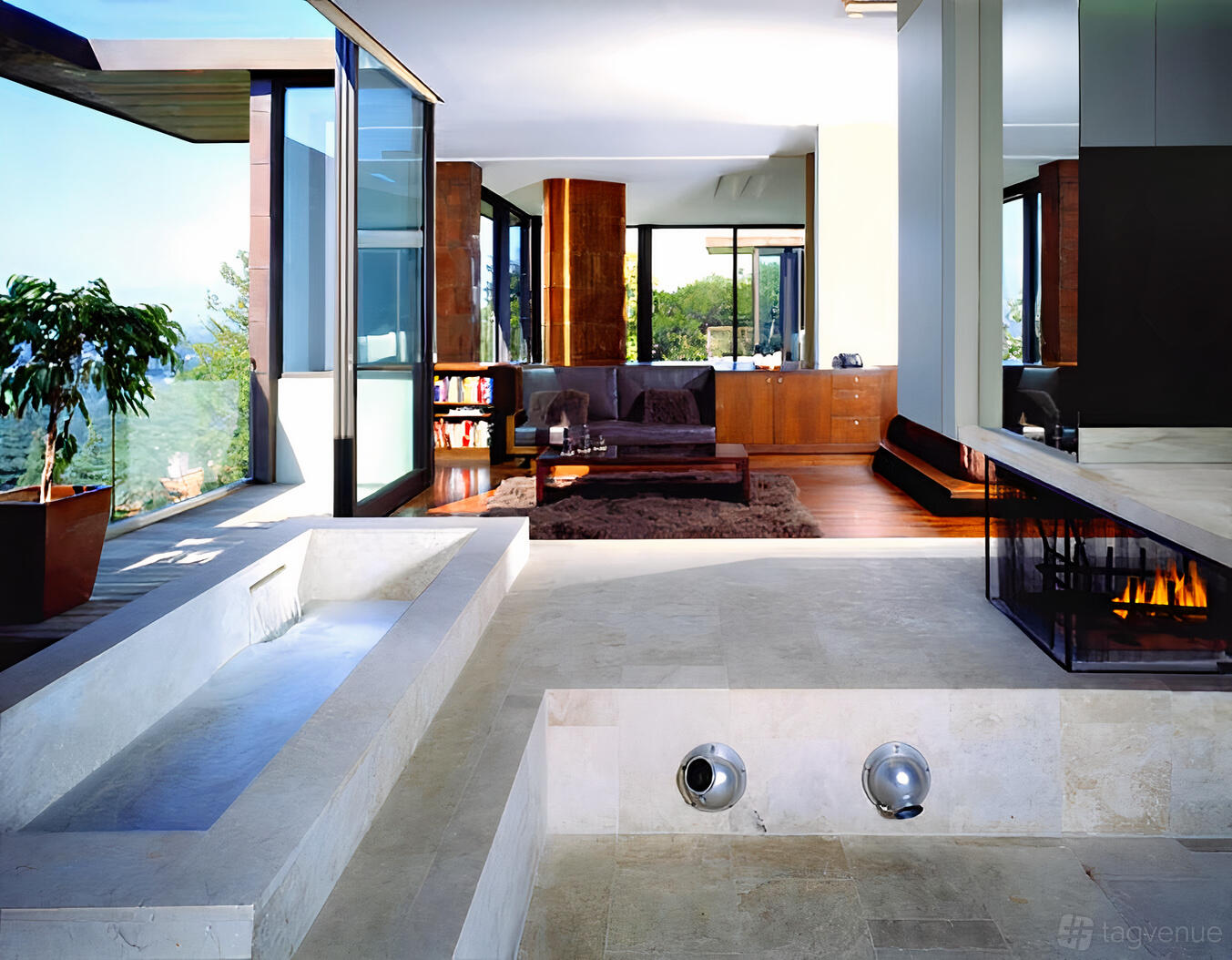 An apartment with floor-to-ceiling windows, indoor water feature, and open living area at Contemporary Mansion.