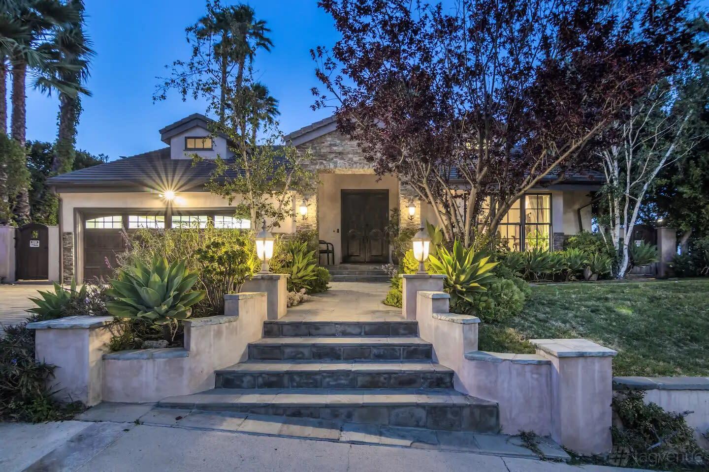 A film and photo studio with stone steps, lush landscaping, and exterior lighting at Tarzana Hills with Amazing View.