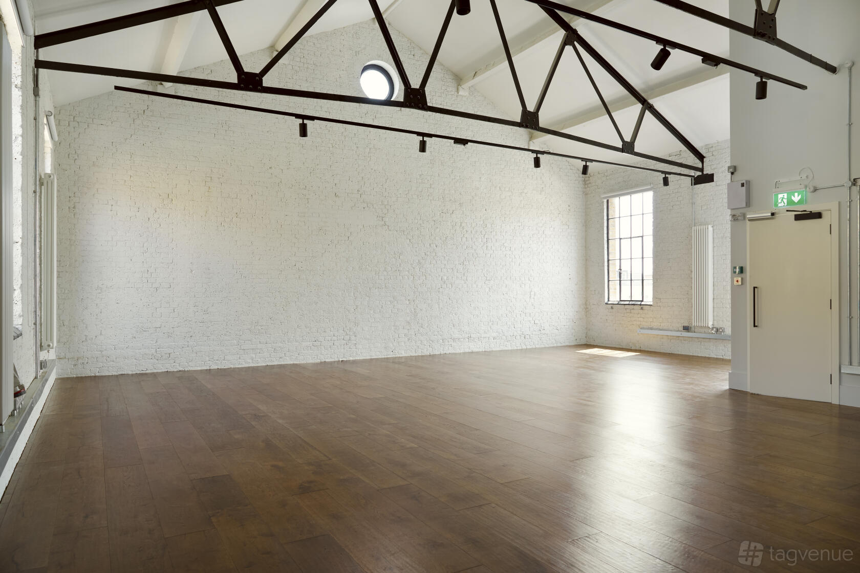 An event venue with white painted brick walls, high ceilings, and exposed steel beams at Springfield House.