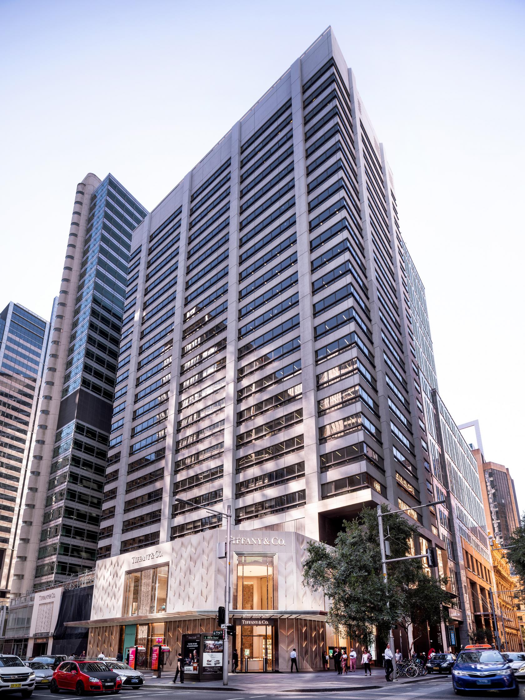 A high-rise office building with large glass windows and concrete facade at JustCo at Pitt Street.