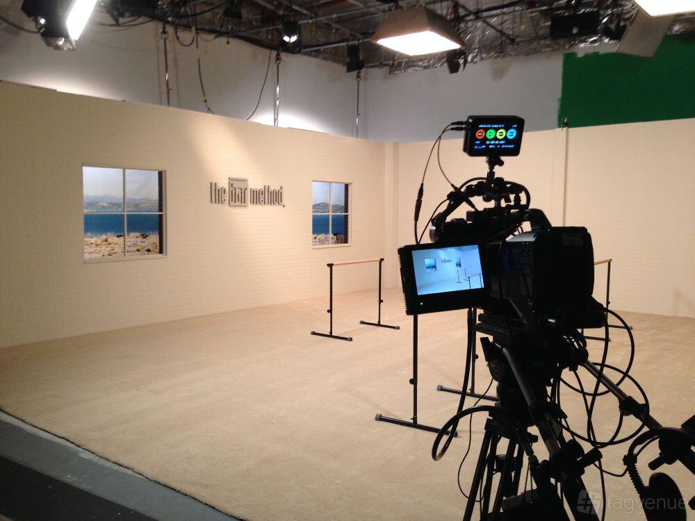 A photo studio stage with mounted cameras, ballet barres, and backdrop windows at Flip2Media.