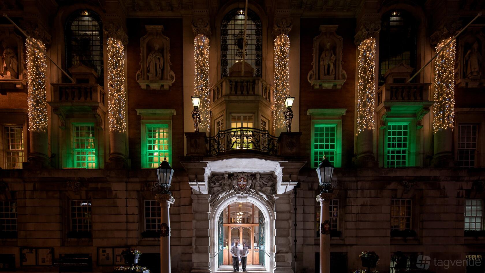 A castle with illuminated stone facade, arched entrance, and decorative columns at Colchester Weddings.