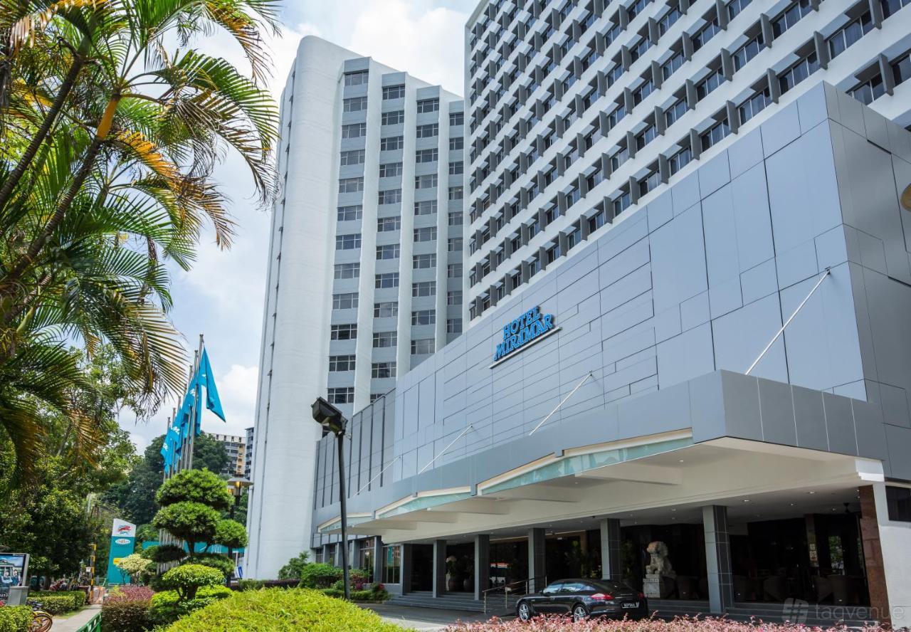 A hotel exterior with modern facade, tall windows, and landscaped entry at Hotel Miramar Singapore.