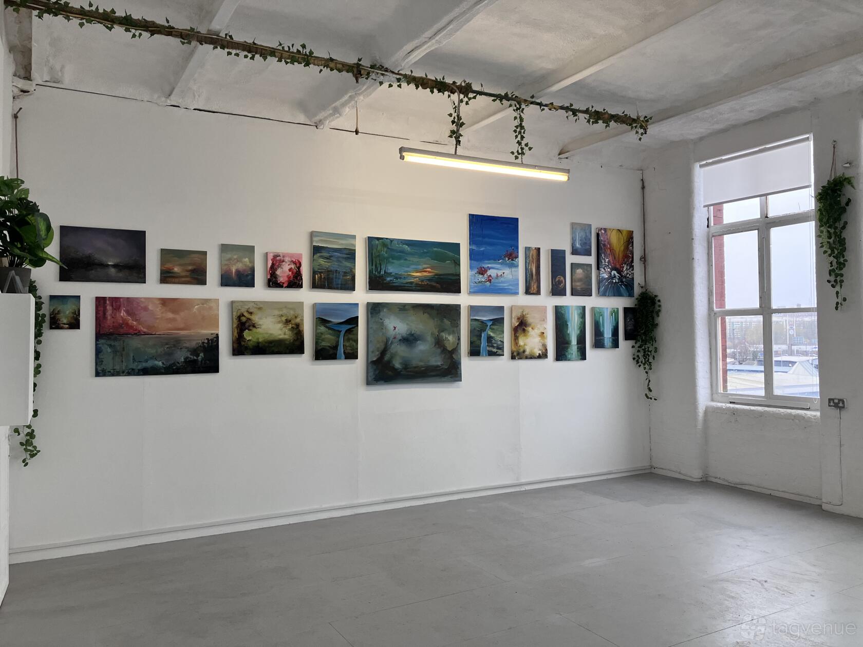 A historic building with white walls, large windows, and contemporary artwork displayed at Vernon Mill.