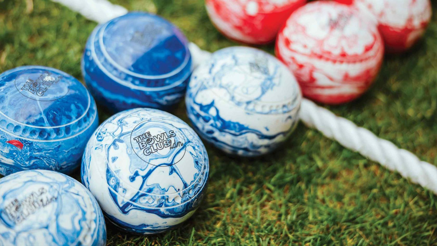 An event venue with lawn bowls featuring blue and white marbled balls on grass at The Bowls Club.