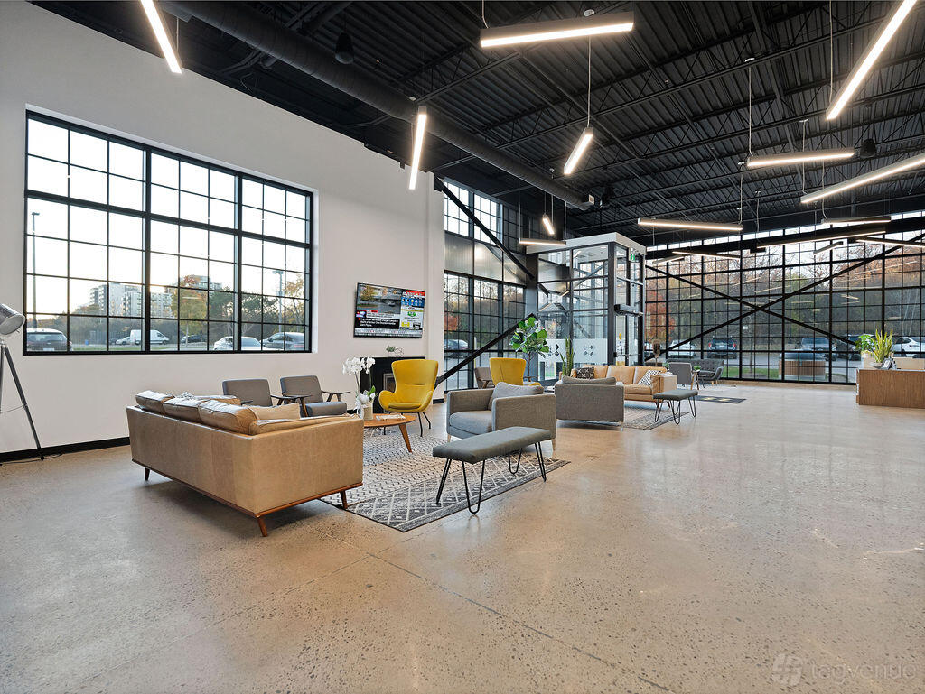 An event venue with large industrial windows, polished concrete floors, and lounge seating at Events Space.