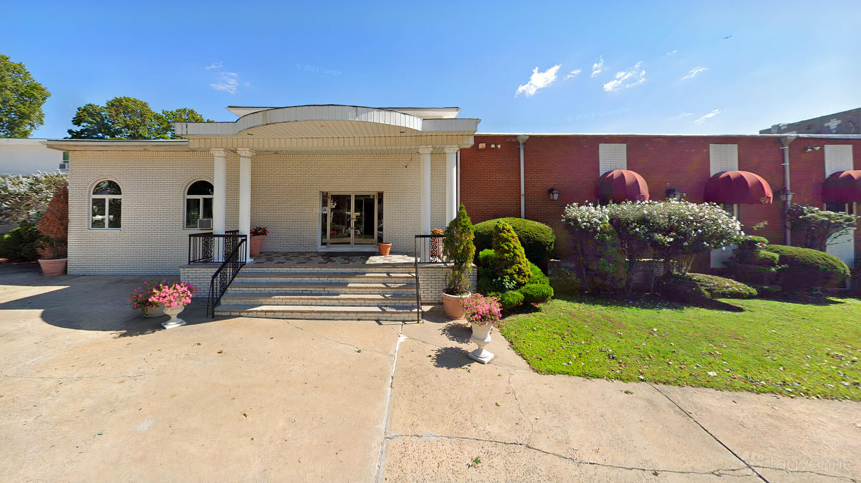 An event venue with a white columned entrance, arched windows, and red brick walls at The Crystal Room.