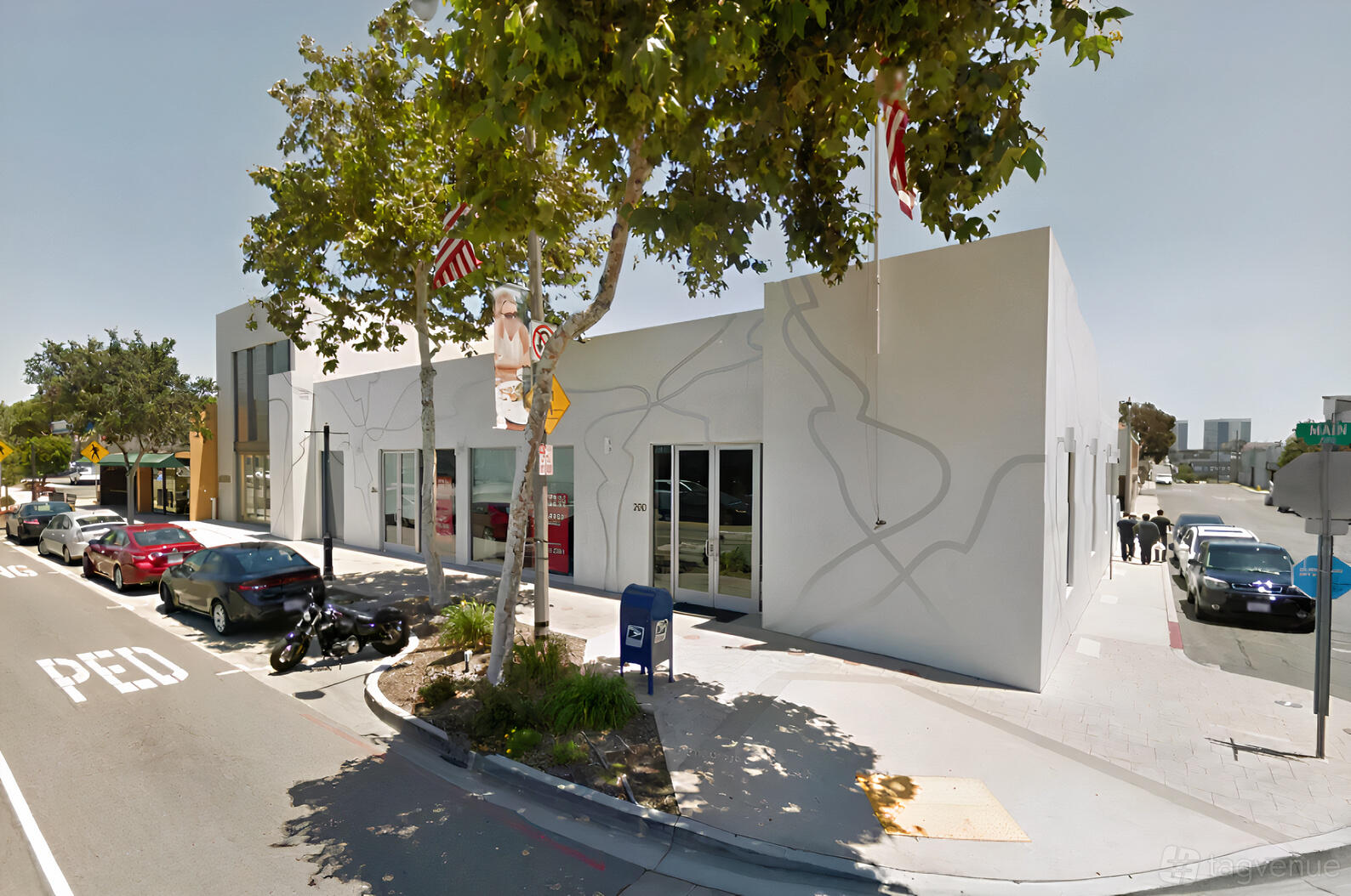 A corner pub with large windows, white exterior walls, and street-facing entrance at Brewport Tap House.