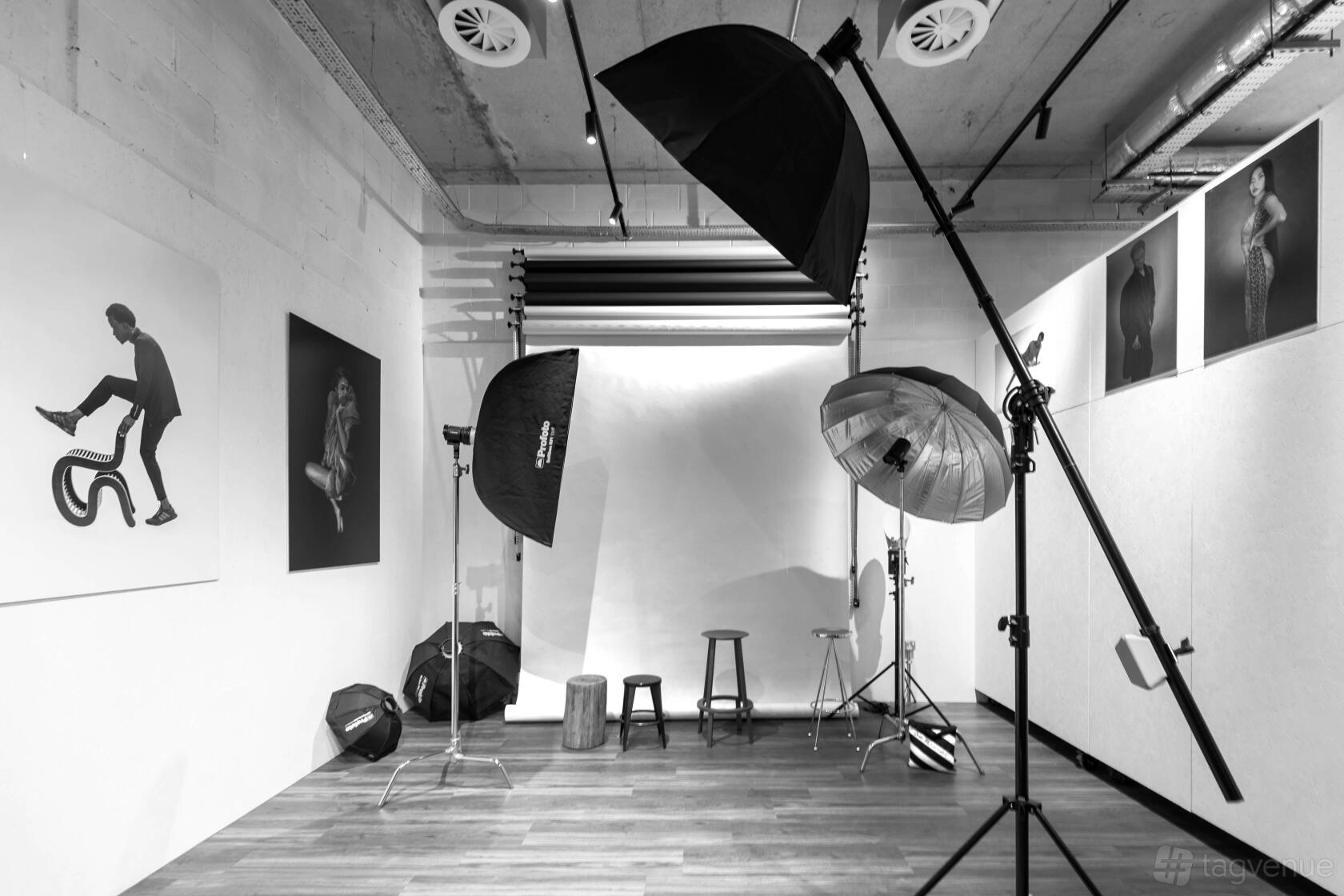 A photo studio with professional lighting equipment, backdrop, and wall-mounted art at London Lighthouse Gallery & Studio.
