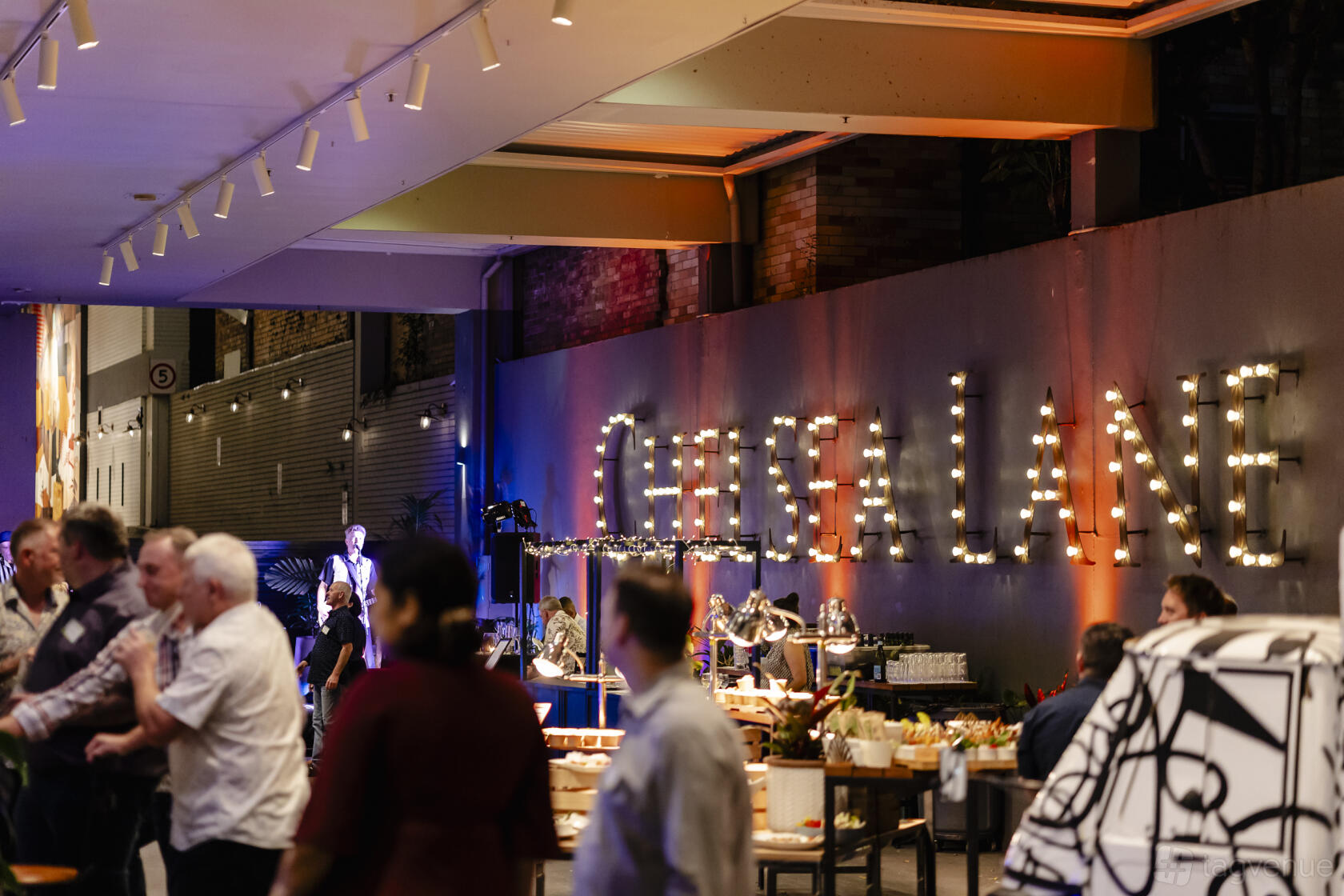 An event space with marquee letter signage, buffet tables, and guests mingling at Voco Hotel Brisbane City Centre.