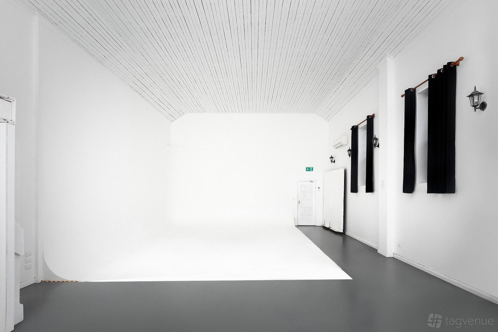 A photo and film studio with a white cyclorama wall, high white ceiling, and black-out curtains at Tempe Studios.