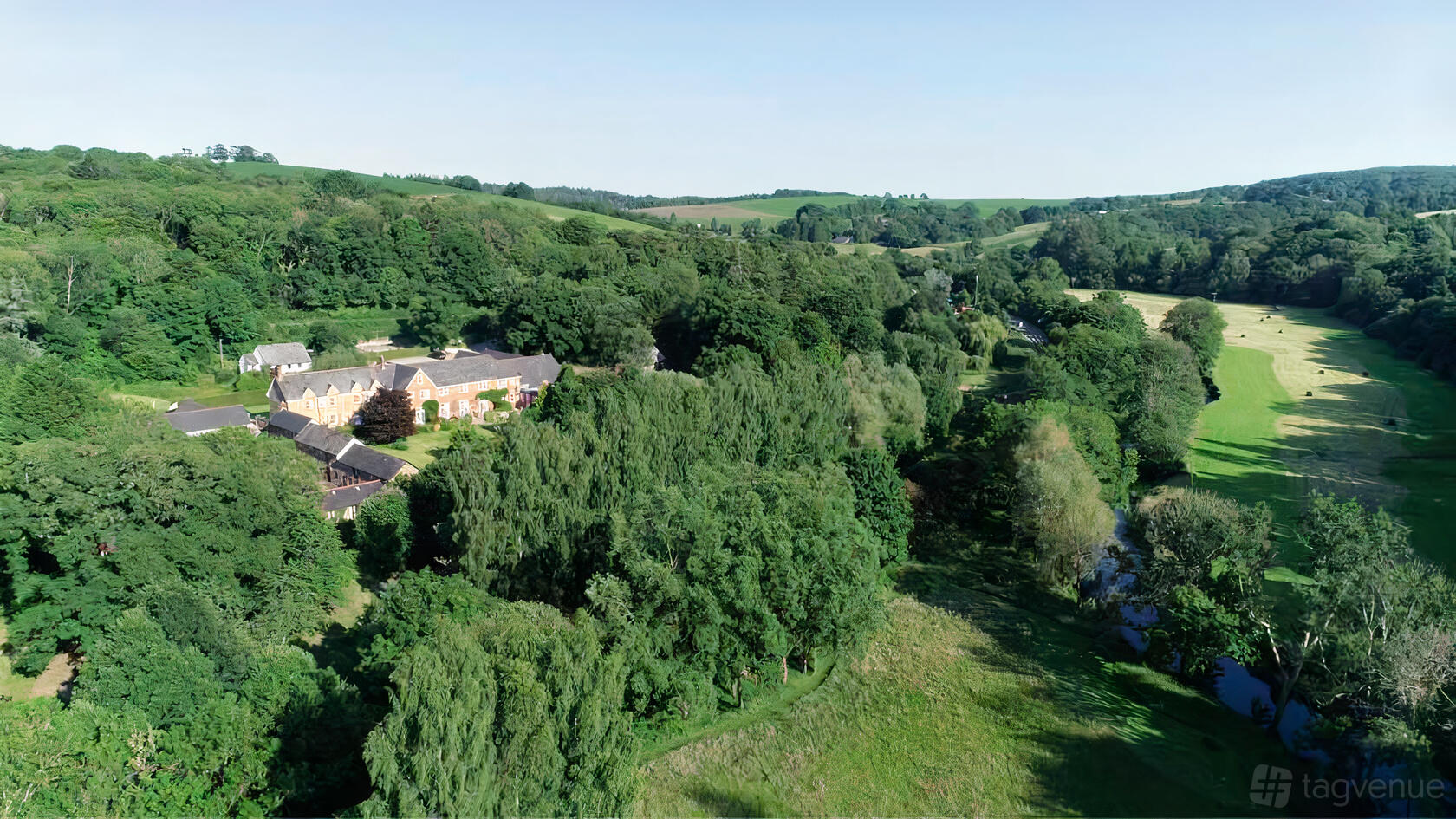A hotel surrounded by dense woodlands and expansive green fields at Fox & Hounds.