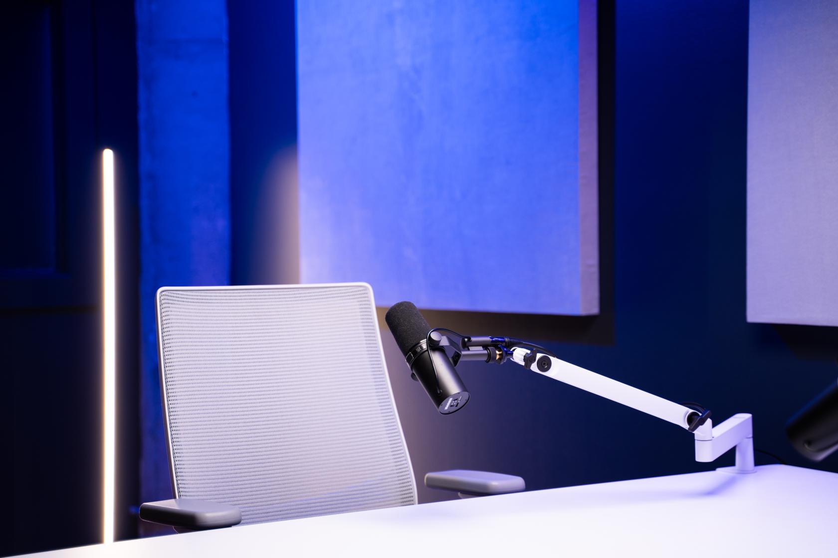 A podcast studio with a white desk, adjustable microphone arm, and acoustic panels at Chicago Podcast Studio.