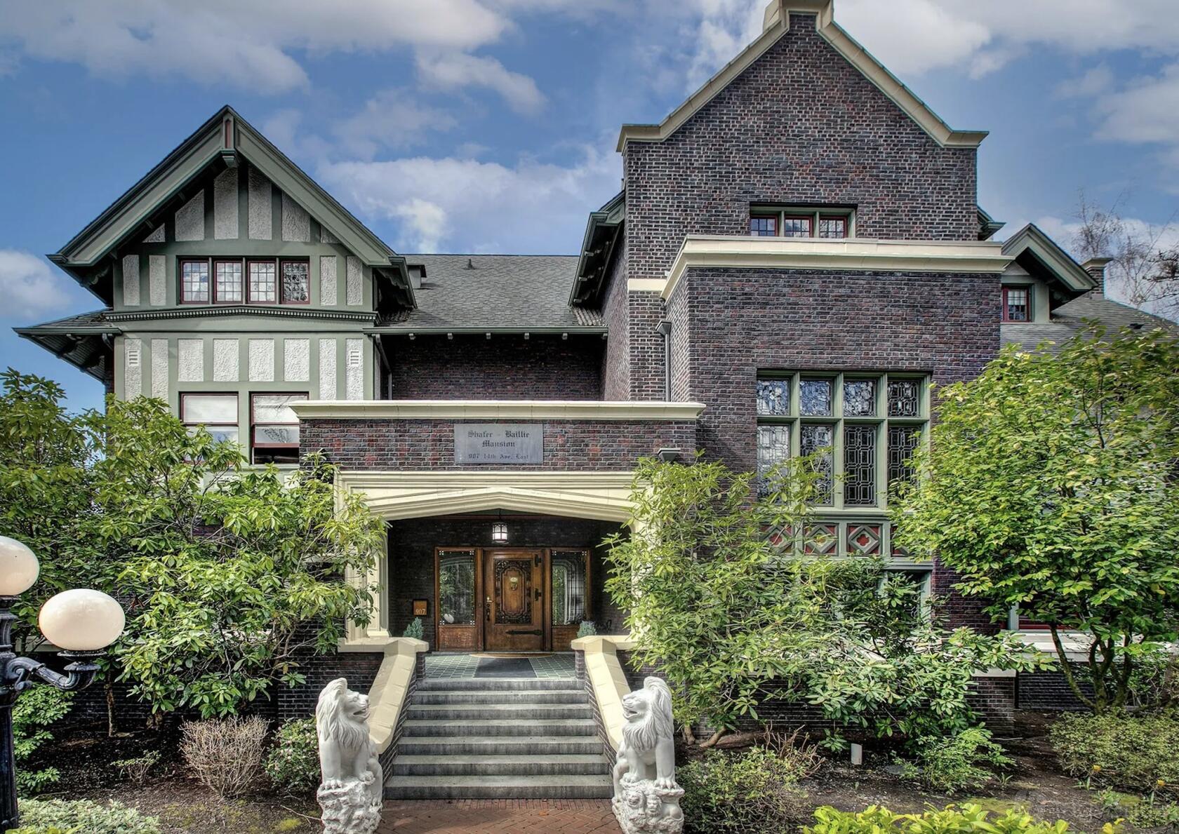 A historic hotel with brick facade, Tudor-style architecture, and stone lion statues at Shafer Baillie Mansion Bed & Breakfast.
