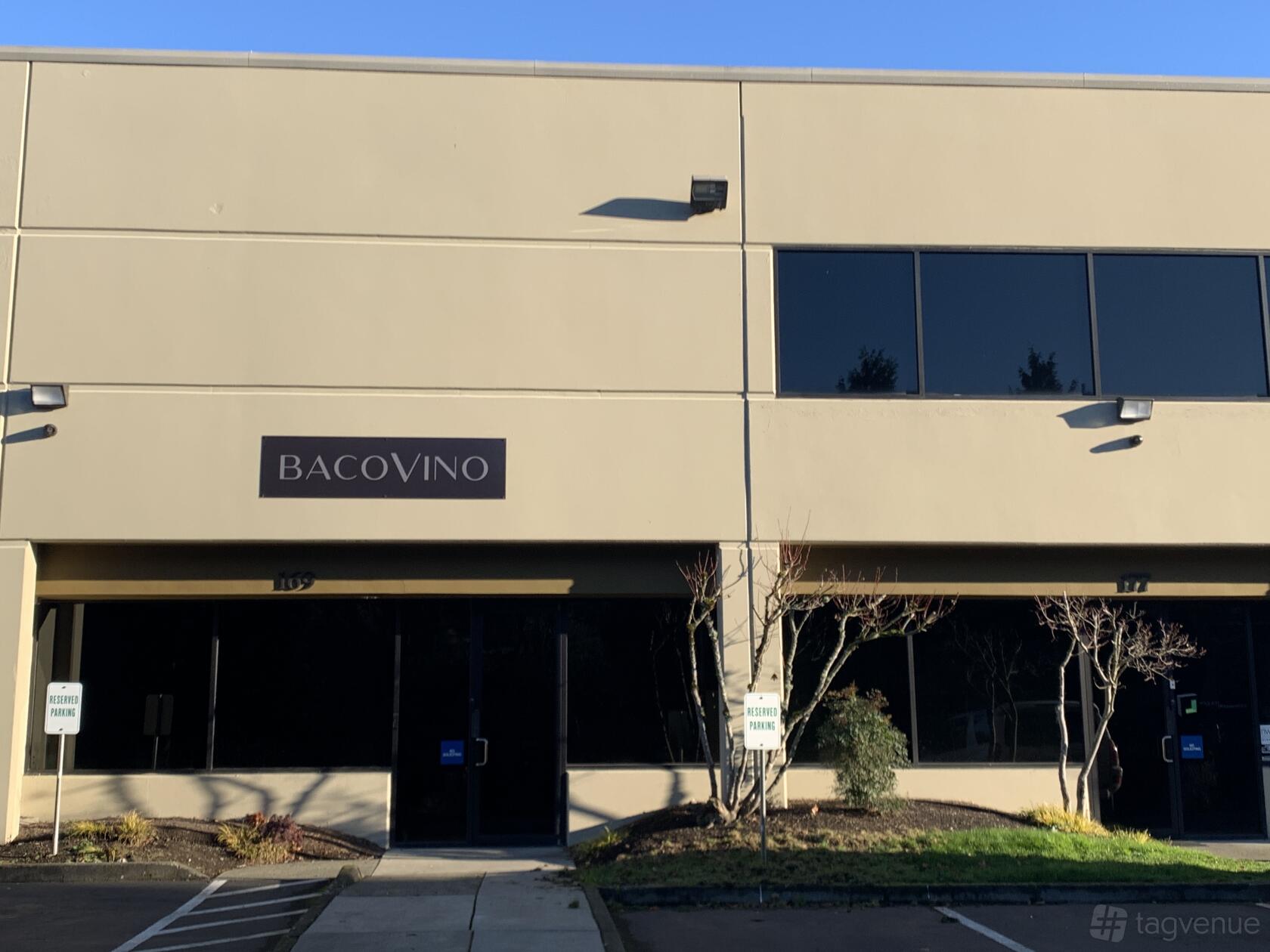 A pub with a beige exterior, large dark-tinted windows, and a Bacovino sign above the entrance.