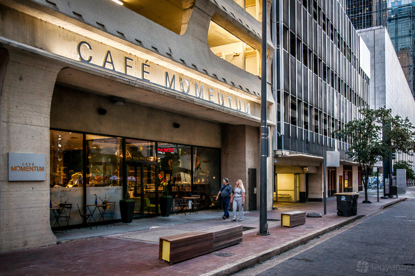A restaurant with floor-to-ceiling windows, outdoor tables, and a prominent sign at Cafe Momentum.