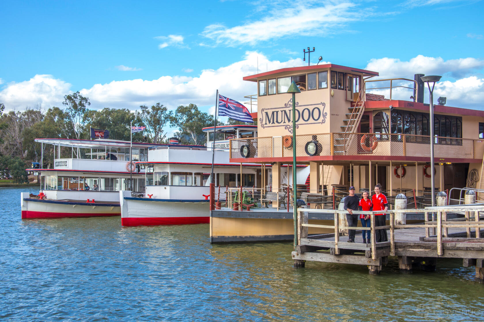 A paddle steamer boat with open decks, lifebuoys, and a docked pier at Mildura Paddle Steamers.