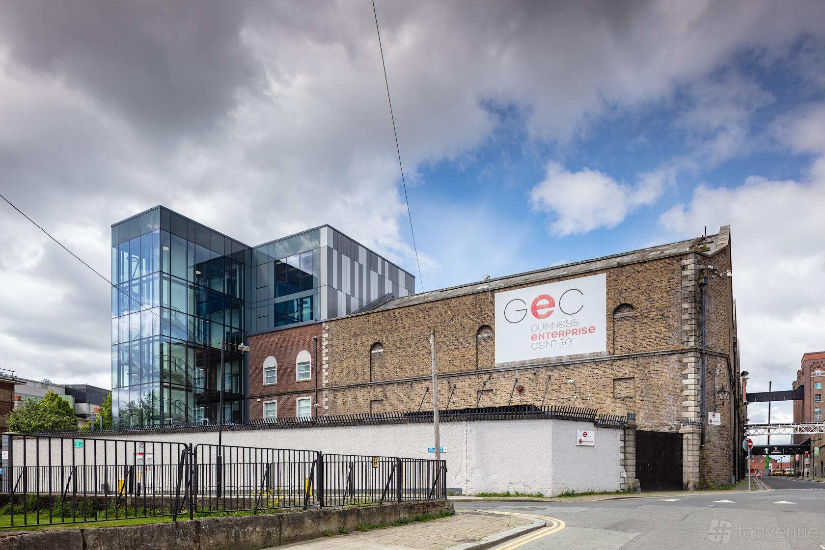 A meeting centre with a glass-fronted modern building adjoining a historic brick facade at The Guinness Enterprise Centre.