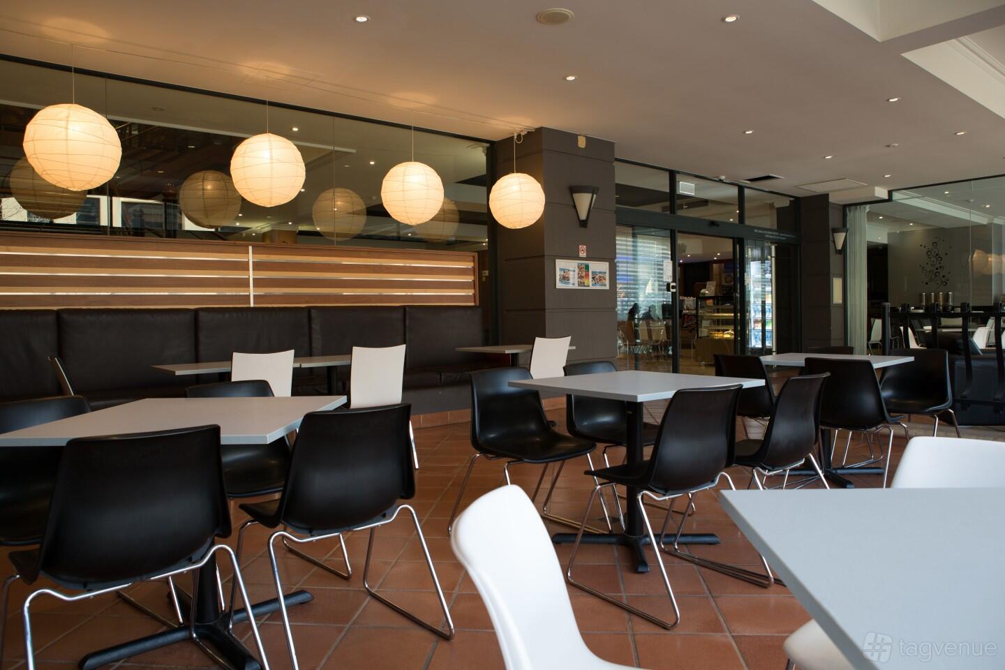 A restaurant with round paper lanterns, black and white chairs, and tiled floors at Restaurant 1903.