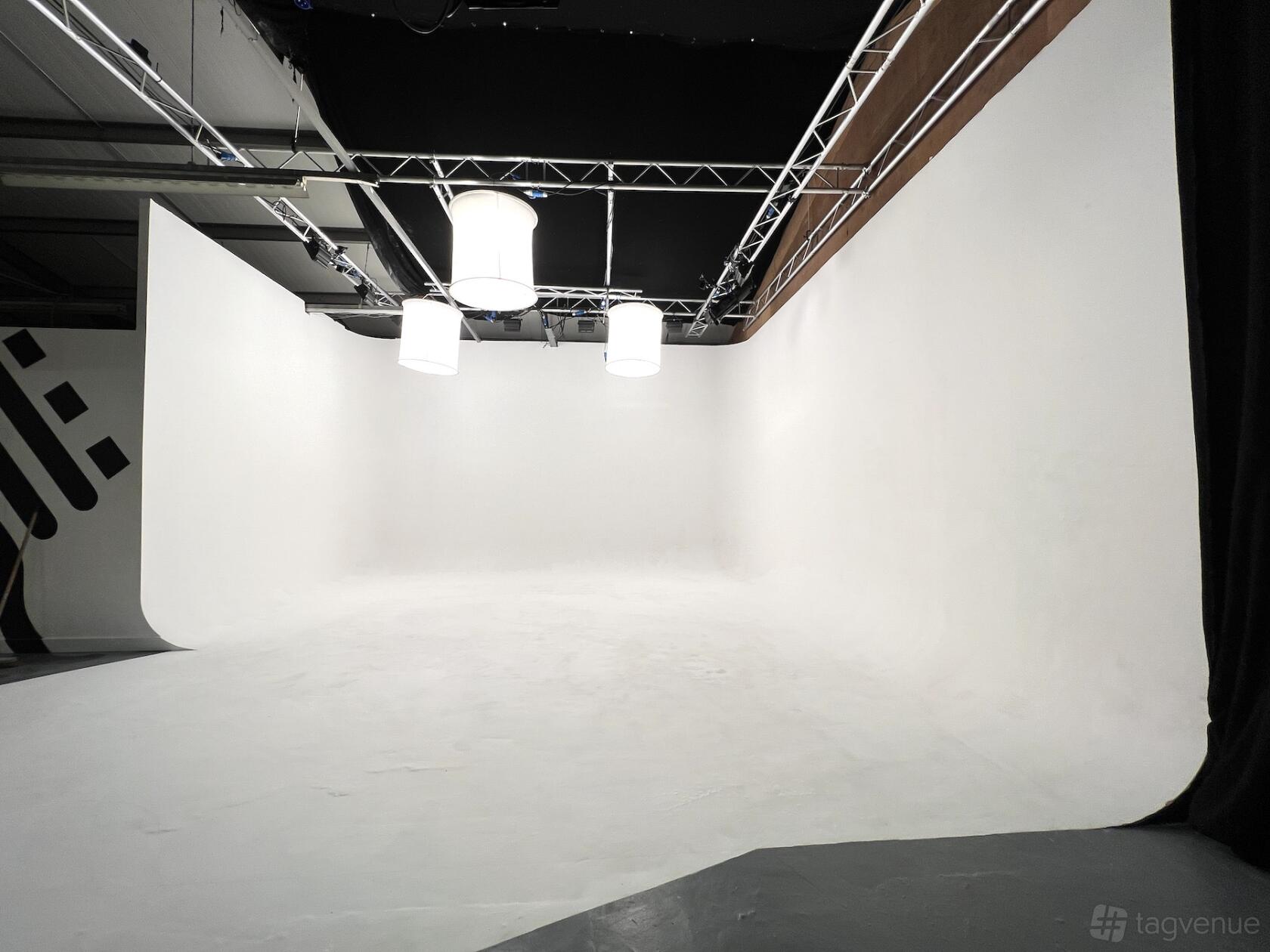 A photo studio with a large white cyclorama wall and overhead softbox lighting at Spaghetti Studio.