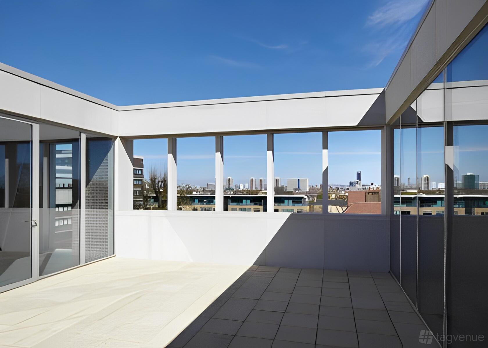 A terrace with open walls, city skyline views, and tiled flooring at ORTUS Conference and Events Venue.