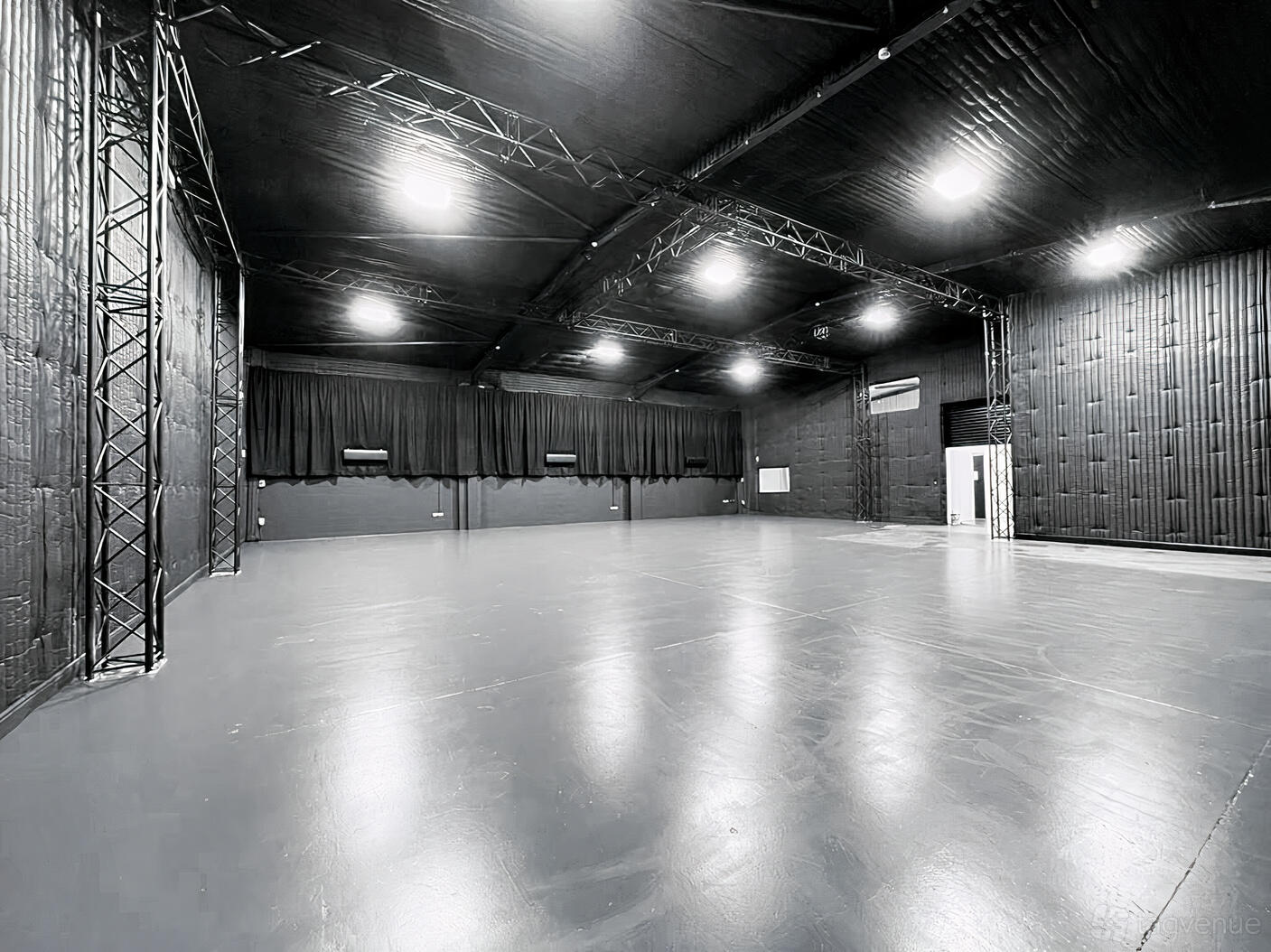 A film studio with black soundproofed walls, high ceilings, and exposed trusses at Silvertown Film Studios.