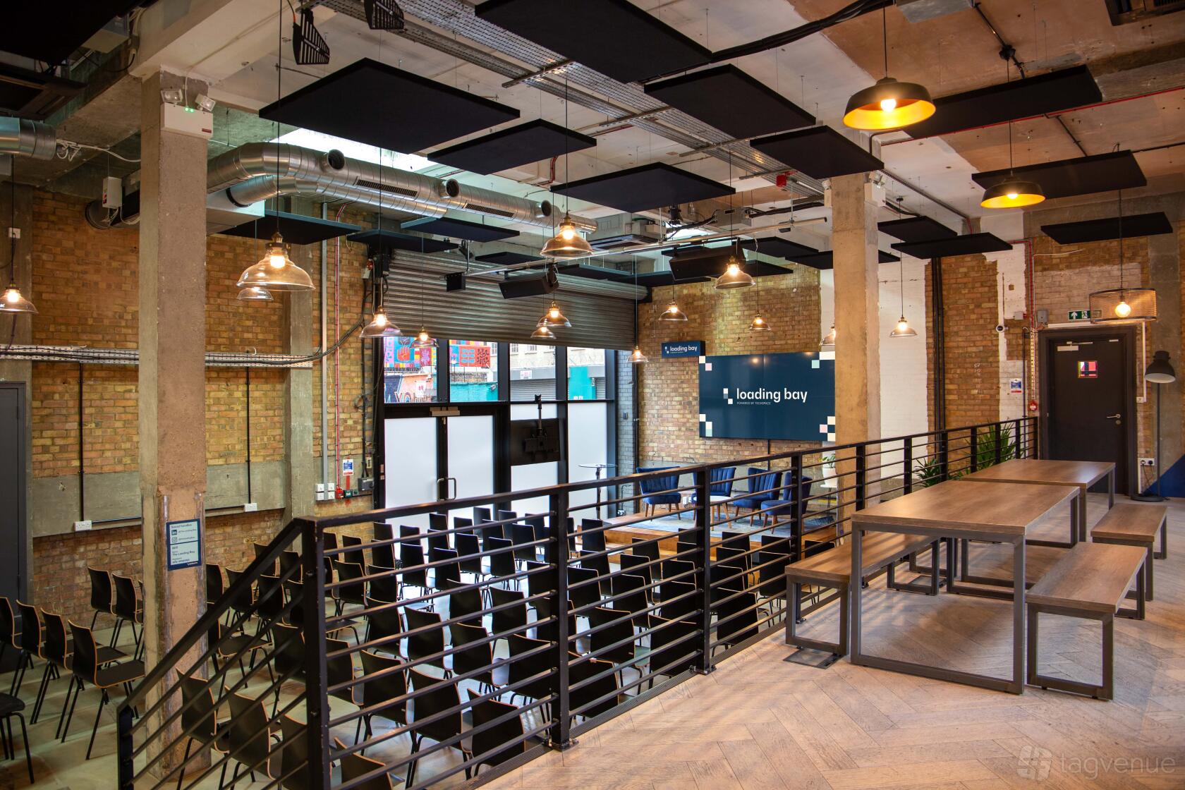 An event space with exposed brick walls, industrial ceilings, and tiered seating at Techspace Shoreditch.