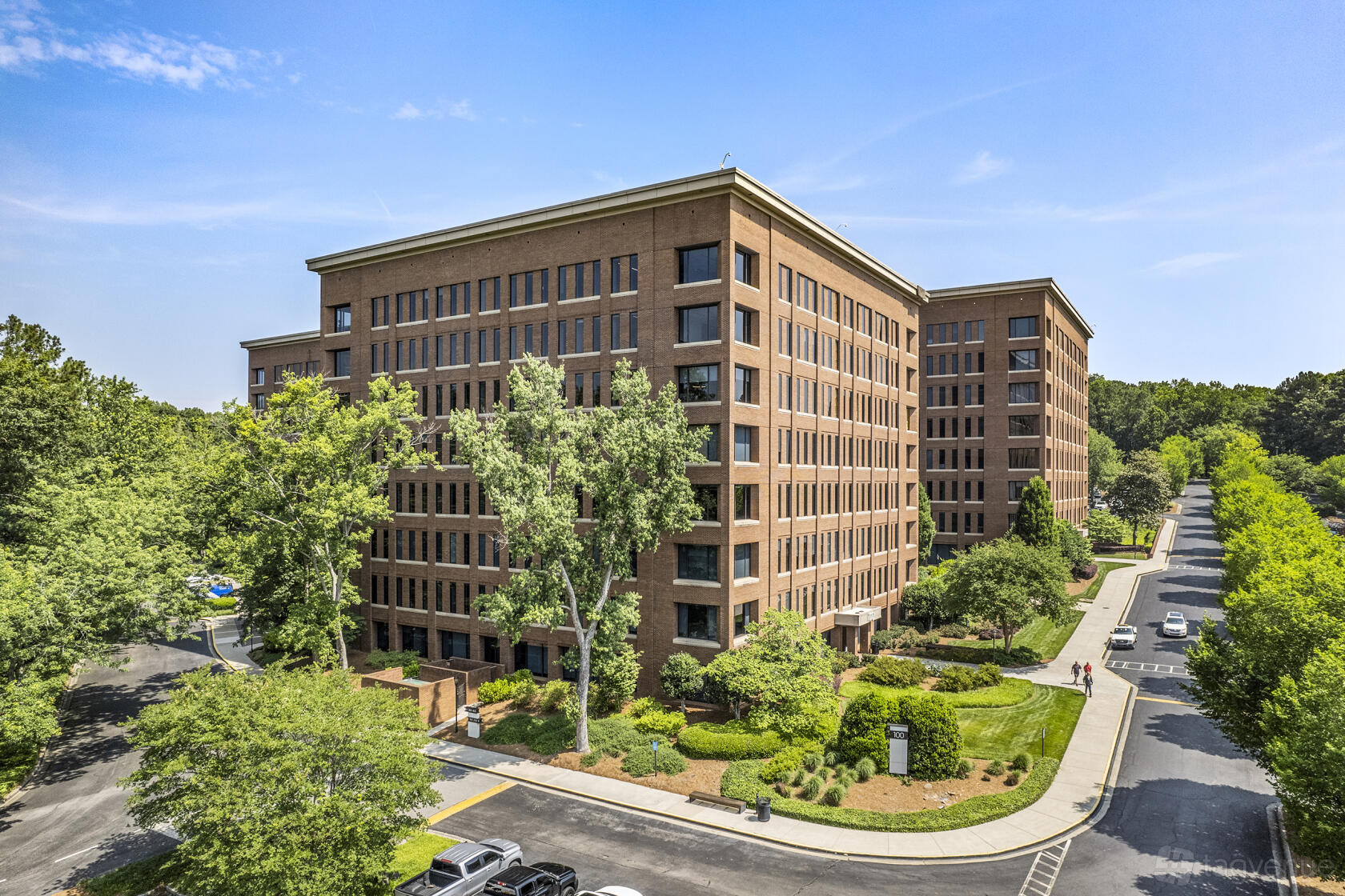 A meeting centre with a red brick exterior, large windows, and landscaped trees at Peachtree Offices at West Paces Ferry.