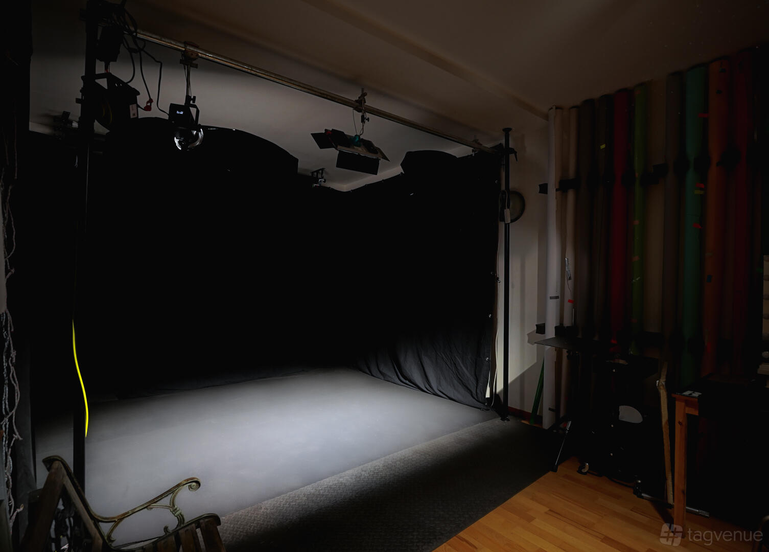A film studio with a blackout photography area, overhead lighting, and colored backdrop rolls at Colores - London photo studio.
