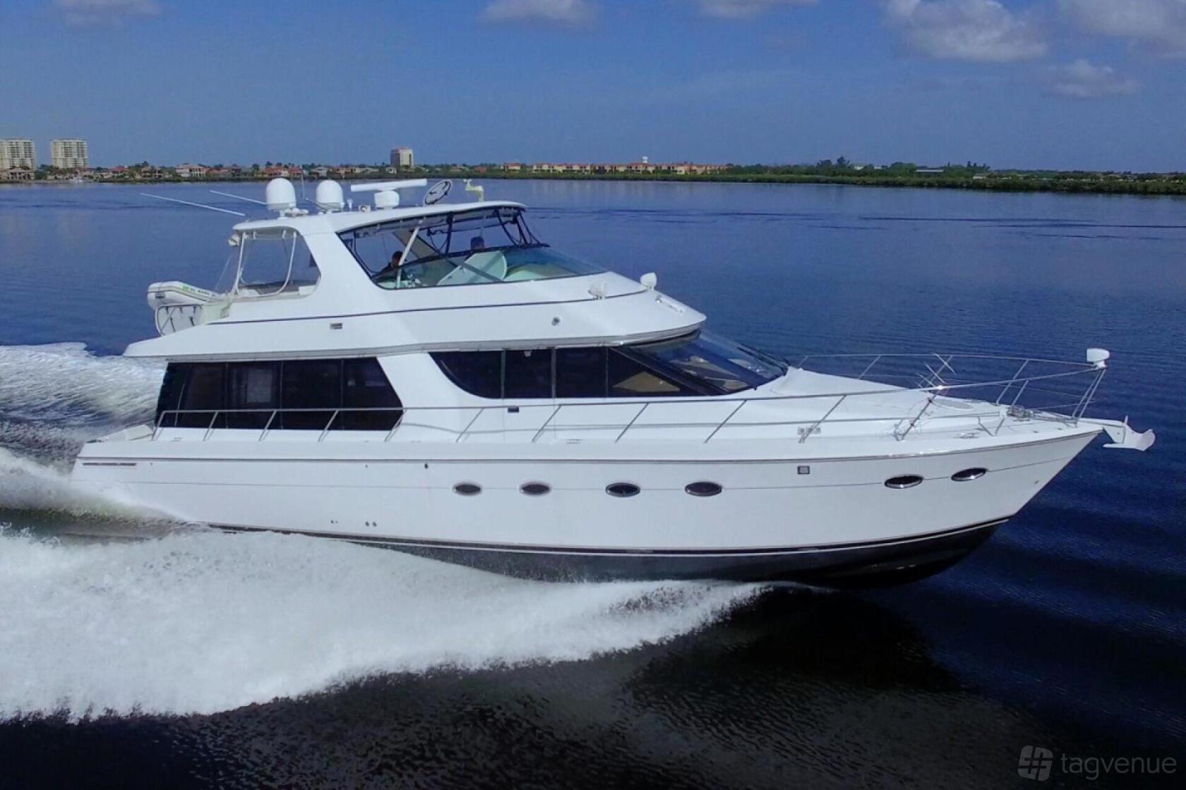 A white luxury yacht cruising on open water with upper deck seating at The Nightfall Group.