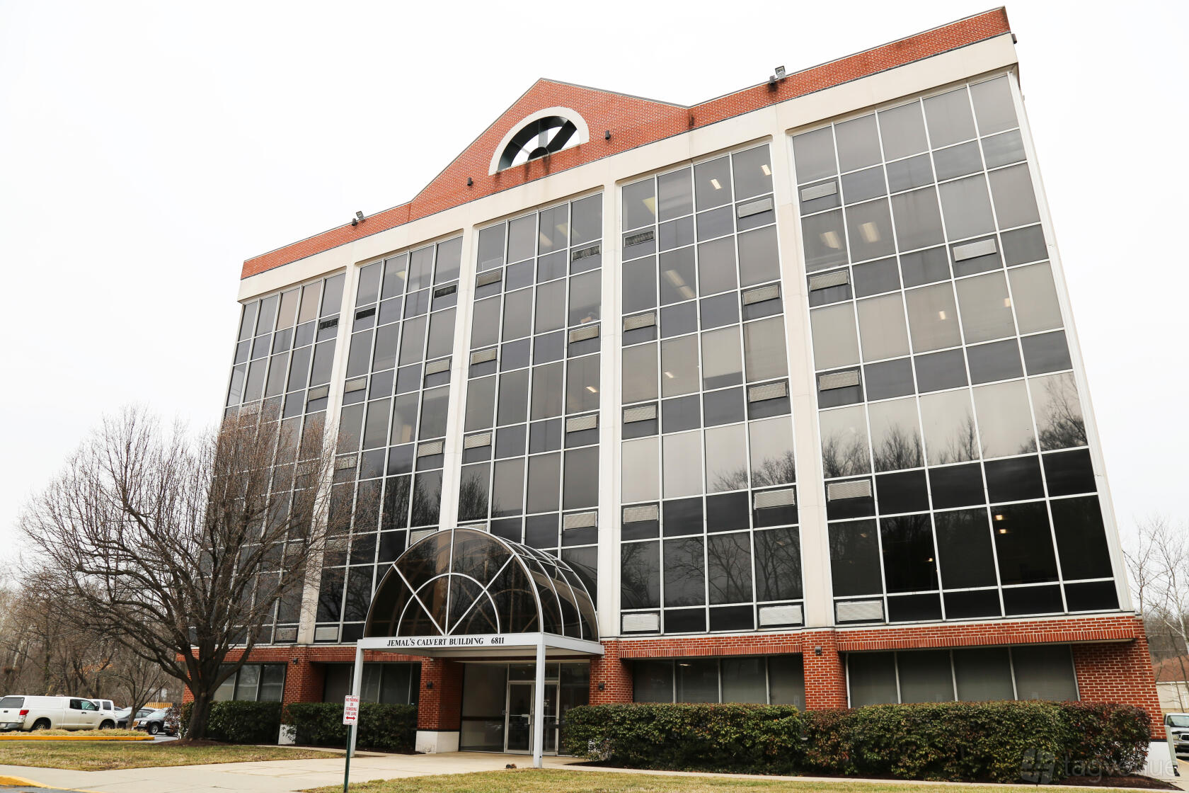 A coworking space with a brick and glass building facade and arched entrance at Perfect Office Solutions - Riverdale 6811.