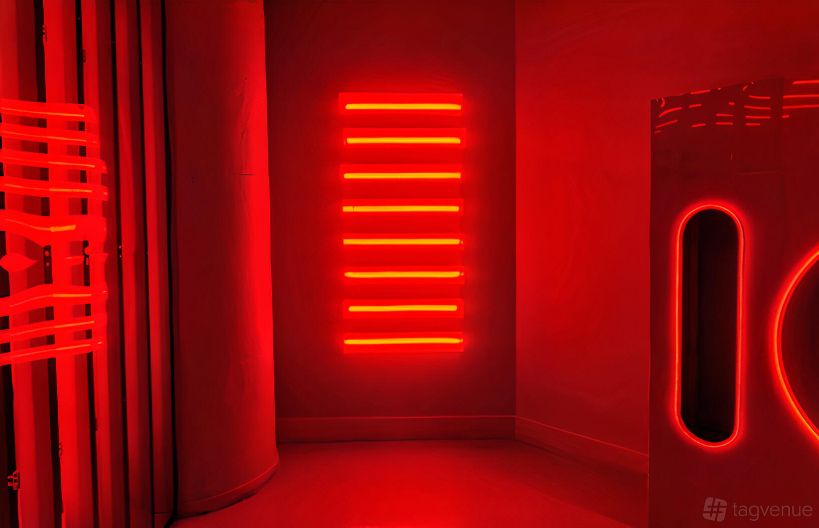 An event venue with bold red lighting, geometric neon wall accents, and curved architectural details at Drip Studios.